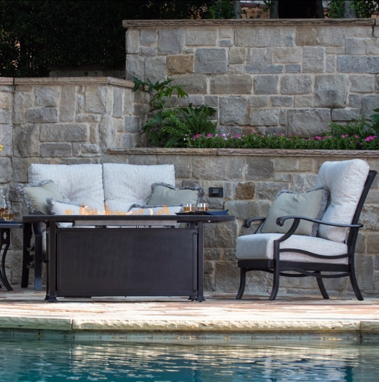 Mallin 60.5" x 36" Paso Robles Rectangular Chat Height Outdoor Fire Table next to furniture